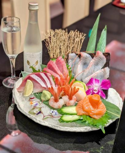 a plate of food on a table with a glass of wine at Anaheim Majestic Garden Hotel in Anaheim
