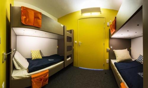 deux lits superposés dans une chambre aux murs jaunes dans l'établissement Résidence Thuria - Spacieux 3 pièces 7/8 personnes MAE-4644, à Arc 1800