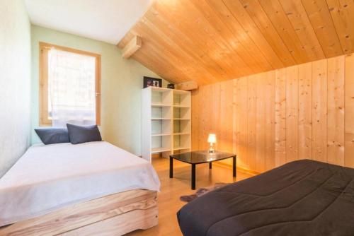 deux lits dans une chambre aux murs en bois dans l'établissement Chalets De La Croisette - Chalet 8 personnes avec hammam MAE-4684, à Arc 1800