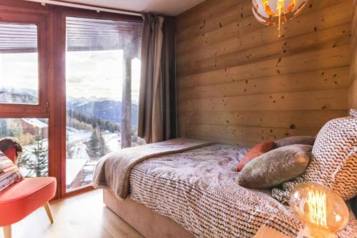 une chambre avec un lit et une grande fenêtre dans l'établissement Résidence Thuria - Spacieux appartement rénové 8 personnes MAE-4704, à Arc 1800