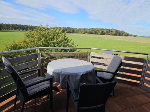 a table and chairs on a deck with a field at Sofija in Neustadt am Rübenberge