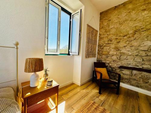 a living room with a bed and a table and a window at Casa do Castelo in Belver