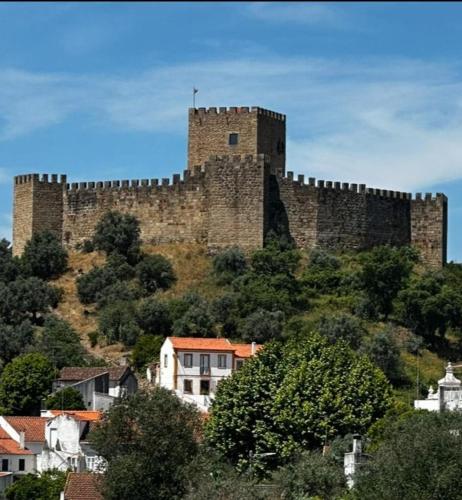 a large castle sitting on top of a hill at Casa do Castelo in Belver