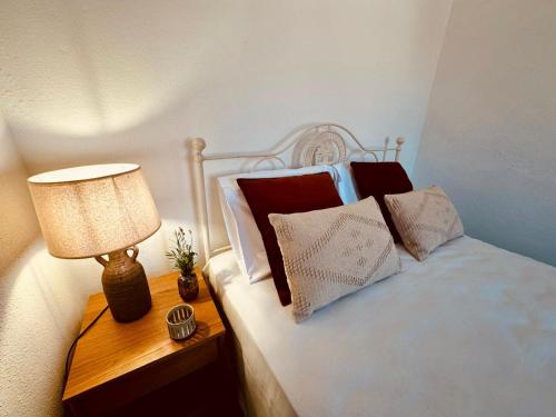 a bedroom with a bed with a lamp and pillows at Casa do Castelo in Belver