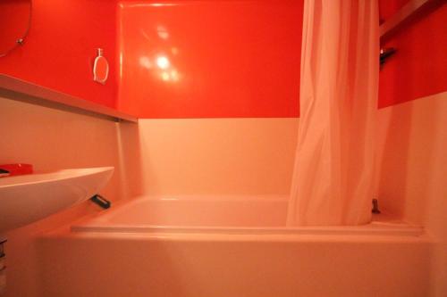 La salle de bains est pourvue d'un rideau de douche à côté d'un lavabo. dans l'établissement Résidence Armoise - Deux pièces 6 personnes centre station MAE-4854, à Arc 1800
