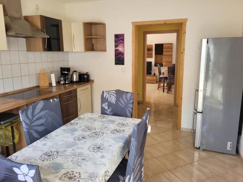 a kitchen with a table and a kitchen with a refrigerator at Ferienwohnung mit Garten - 10 Minuten von Templin in Milmersdorf