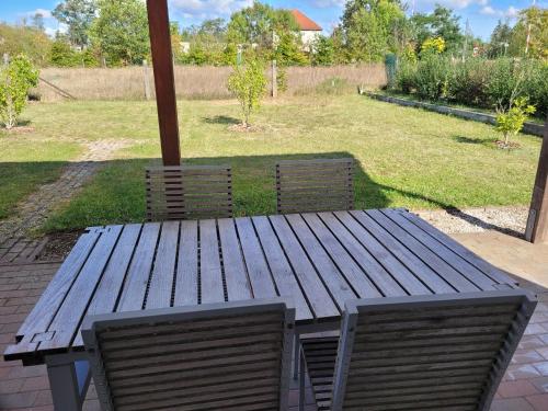 a wooden picnic table with two chairs and an umbrella at Ferienwohnung mit Garten - 10 Minuten von Templin in Milmersdorf