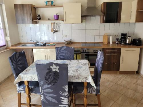 a kitchen with a table and chairs in it at Ferienwohnung mit Garten - 10 Minuten von Templin in Milmersdorf