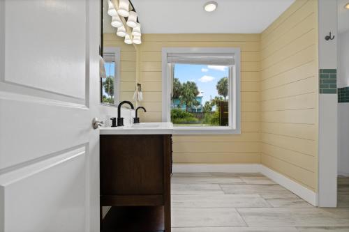 ペンサコーラ・ビーチにあるSunny Daze Beach Houseのシンクと窓のあるキッチン