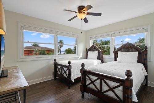 ペンサコーラ・ビーチにあるSunny Daze Beach Houseの窓が2つある寝室にベッドが2つある