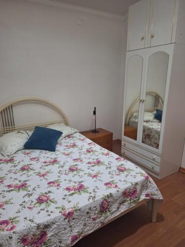 a bedroom with a bed with a floral bedspread and a dresser at House Prosperity in Amora