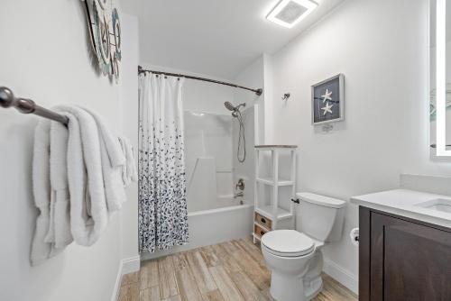 a white bathroom with a toilet and a shower at Bayside Bliss in Pensacola