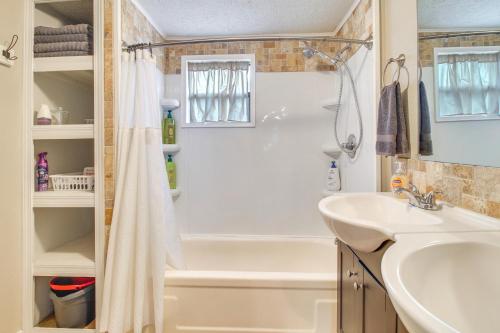 a bathroom with a white tub and a sink at Half-Mi to Marina Pet-Friendly Disney Home in Disney