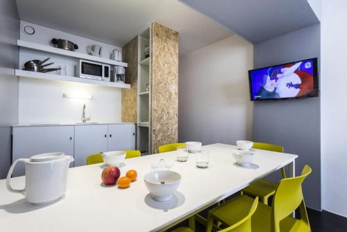 une cuisine avec une table blanche et des chaises jaunes dans l'établissement Résidence Varet 3 - Studio rénové 5 personnes MAE-5314, à Arc 2000