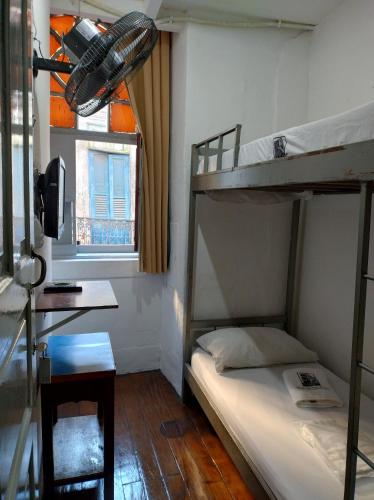 a bedroom with two bunk beds and a desk at Hospedagem Ledo in Rio de Janeiro