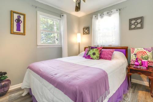 a bedroom with a large bed with a purple blanket at 8 Mi to Sloppy Floyd State Park Peaceful Retreat! in Summerville