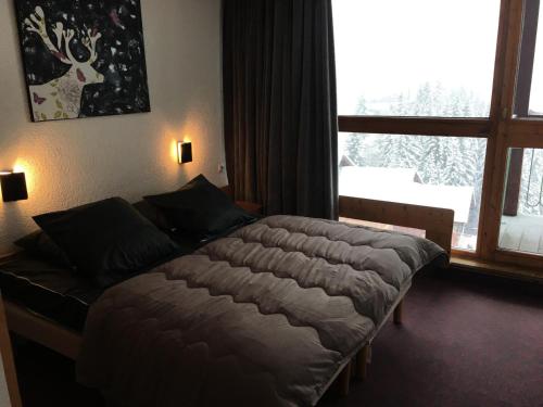 une chambre avec un grand lit et une fenêtre dans l'établissement Résidence Tournavelles 2 - Spacieux appartement 10 personnes front de neige MAE-5484, à Arc 1800