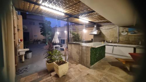 a kitchen with a sink and a counter with plants at Hospedagem da Família hostel in Cabo Frio