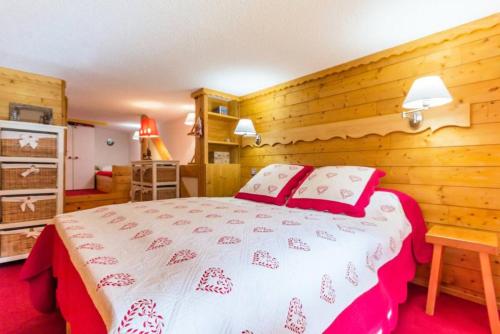 une chambre avec un lit dans une pièce aux murs en bois dans l'établissement Résidence Aiguille Grive 2 - Duplex meublé pour 5/6 personnes au calme MAE-5534, à Arc 1800