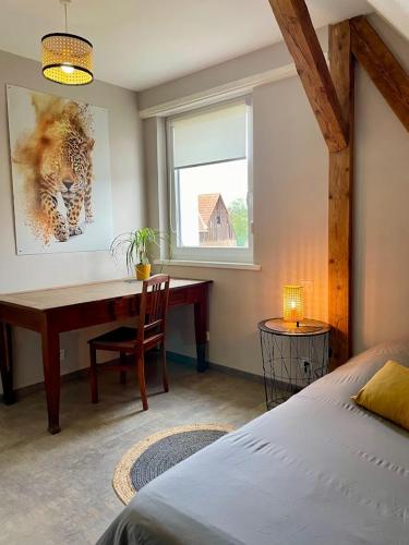 a bedroom with a desk and a bed and a window at Chez L en Alsace Maison indépendante 8 pers Jardin & Cour privative in Griesheim-près-Molsheim