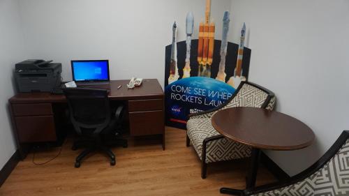 an office with a desk with a computer and chairs at ISLAND HOTEL of Space Coast in Merritt Island