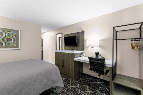 a hotel room with a bed and a desk and a television at Quality Inn Oskaloosa in Oskaloosa