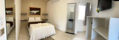 a room with a bed and a white table in it at Pousada La Belle in Maragogi