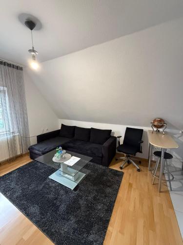 a living room with a black couch and a table at Hammer Wohnung in Hamm