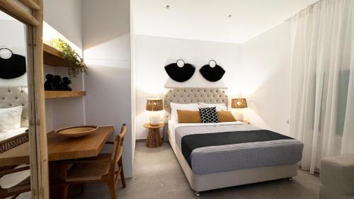 a bedroom with a bed and a table and a desk at Angel Syros Luxury Apartment in Ermoupoli