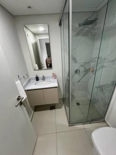 a bathroom with a glass shower and a sink at Departamento Home Ycua Sati in Asunción