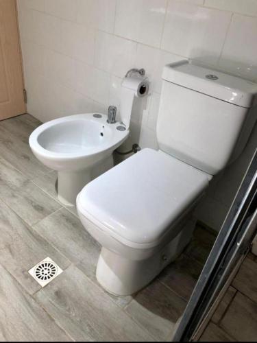 a bathroom with a white toilet and a sink at Nelly in La Paloma