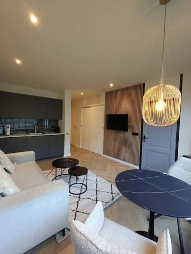 a living room with a couch and a table at Modern appartement vlak bij strand in Vlissingen