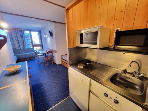une cuisine avec un évier et un micro-ondes dans l'établissement Résidence Belles Challes - Studio 4 personnes pied des pistes MAE-6094, à Arc 1800