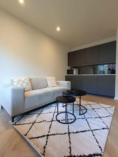 a living room with a couch and two tables at Modern appartement vlak bij strand in Vlissingen
