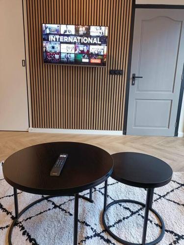 a table and two stools in a room with a door at Modern appartement vlak bij strand in Vlissingen