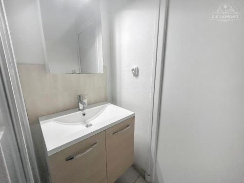 une salle de bain avec un lavabo et un miroir dans l'établissement Balcon, Vue dégagée & Proche gare, à Vichy
