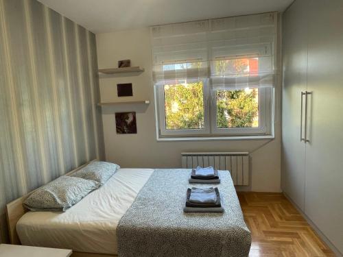 a small bedroom with a bed and a window at Comfy & Cozy Apartment - parking in Karaburma