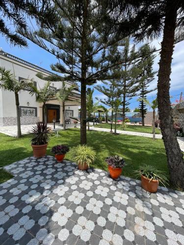 a park with trees and potted plants on a sidewalk at Villa Safaa Dar Bouazza in Dar Mouddene