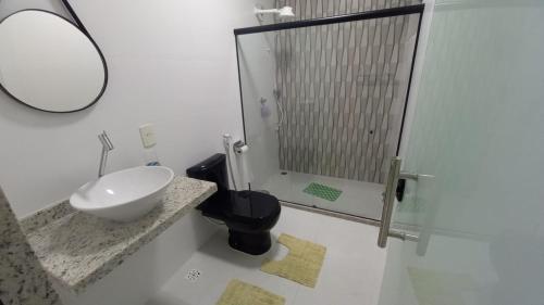 un bagno con lavandino e doccia con specchio di Casa de praia toda mobiliada na primeira quadra da ilha de Guriri São Mateus ES a São Mateus