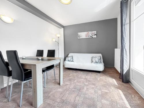 - une salle à manger avec une table, des chaises et un lit dans l'établissement Balcon, Vue dégagée & Proche gare, à Vichy