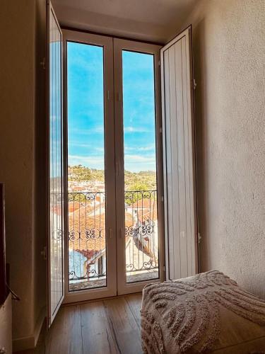a bedroom with a large glass door with a balcony at Casa do Castelo in Belver