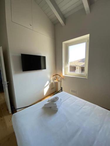 a bedroom with a white bed and a window at ALMA i luoghi dell anima in Diano dʼAlba