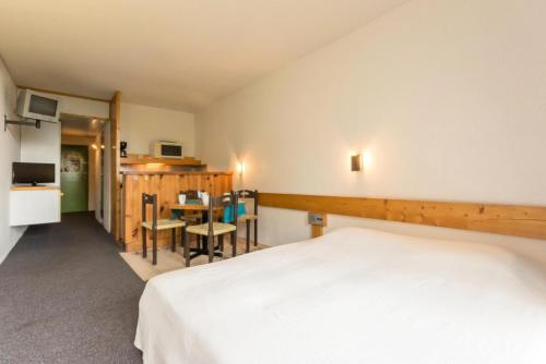 une chambre avec un lit, une table et des chaises dans l'établissement Résidence Varet 2 - Studio 5 personnes MAE-6454, à Arc 2000
