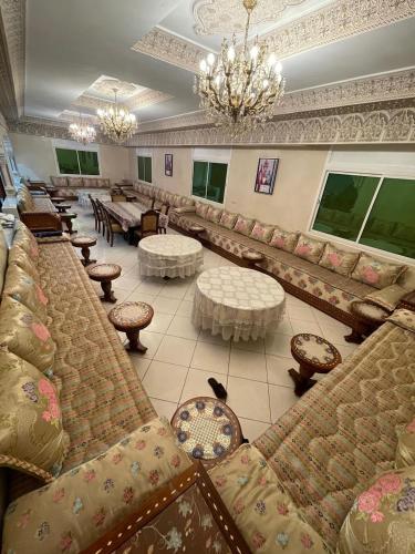 a lobby with couches and tables and a chandelier at Villa Safaa Dar Bouazza in Dar Mouddene