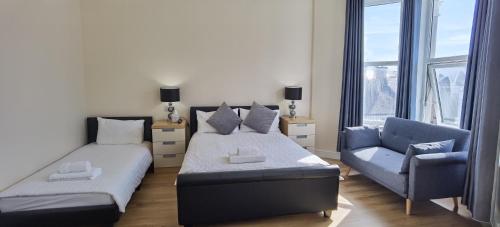 a bedroom with a bed and a couch and a chair at Comfy 2 bedroom Apt in central location, Newly Refurbished in Plymouth
