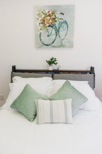 a bed with white pillows and a bike on the wall at Harty's Terrace 9 Kimball Avenue in Yonkers
