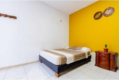 a bedroom with a bed and a yellow wall at Habitaciones Vacacionales - Room Vacational By BB in Gaira