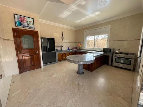 a large kitchen with a table in the middle of it at Villa Safaa Dar Bouazza in Dar Mouddene