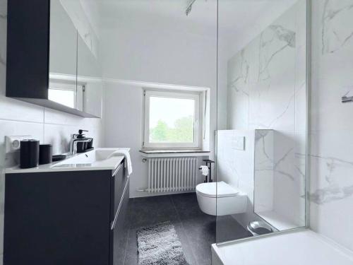 ein weißes Bad mit einem WC und einem Fenster in der Unterkunft Charming 5bedroom Home with gym,garden,parking&terrace-HOL15 in Luxemburg (Stadt)