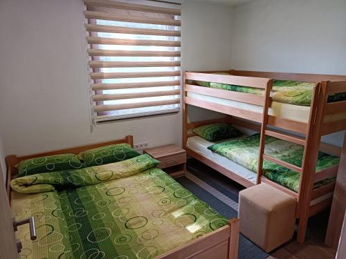 トラヴニクにあるApartmani Vila Alpeの二段ベッド2台と窓のある寝室